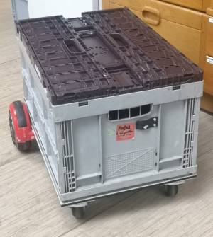 Das Hoverboard mit einer 60x40x28 cm Euro-Klappbox drauf, darauf eine weitere, flachere, zusammengeklappte Klappbox als Deckel