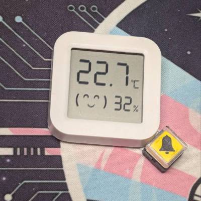 Thermometer wieder im Gehäuse, unten rechts an der Ecke befindet sich eie quadratische, 45° gedrehte, gelbe Taste, die mit einem Klingelsymbol versehen ist. Thermometer wieder im Gehäuse, unten rechts an der Ecke befindet sich eie quadratische, 45° gedrehte, gelbe Taste, die mit einem Klingelsymbol versehen ist.